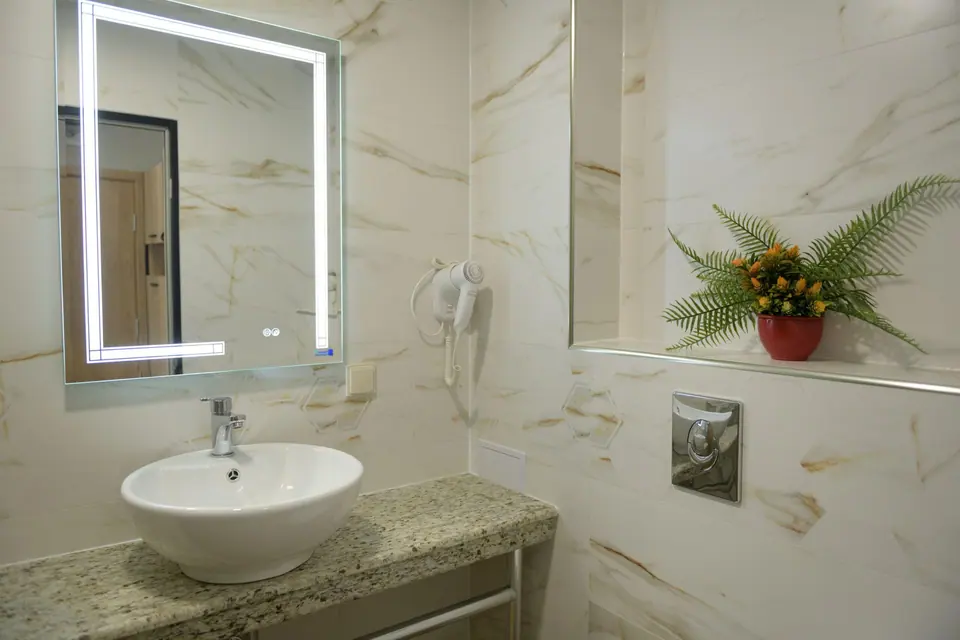 Bad mit beleuchtetem Spiegel – Hotel Forum City, Pasardschik