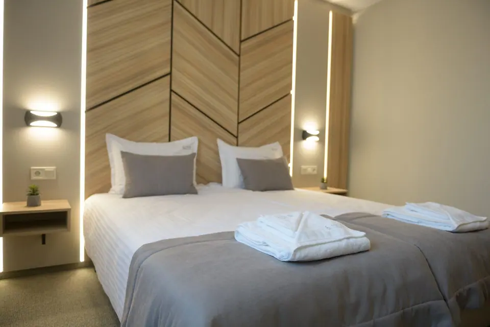 Room with a large bed and wooden feature wall – Forum City Hotel, Pazardzhik