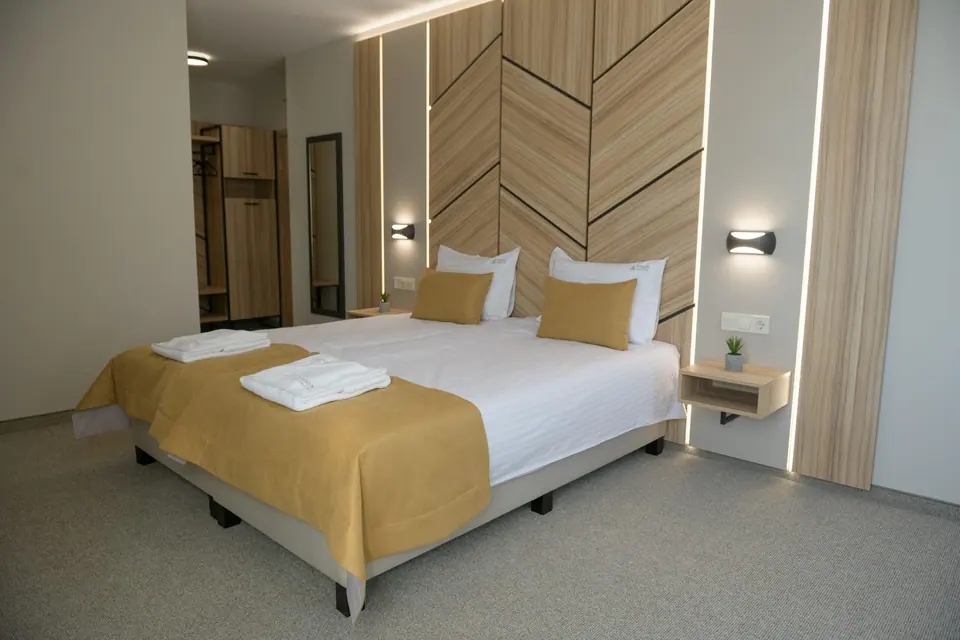 Room with a large bed and wooden feature wall – Forum City Hotel, Pazardzhik